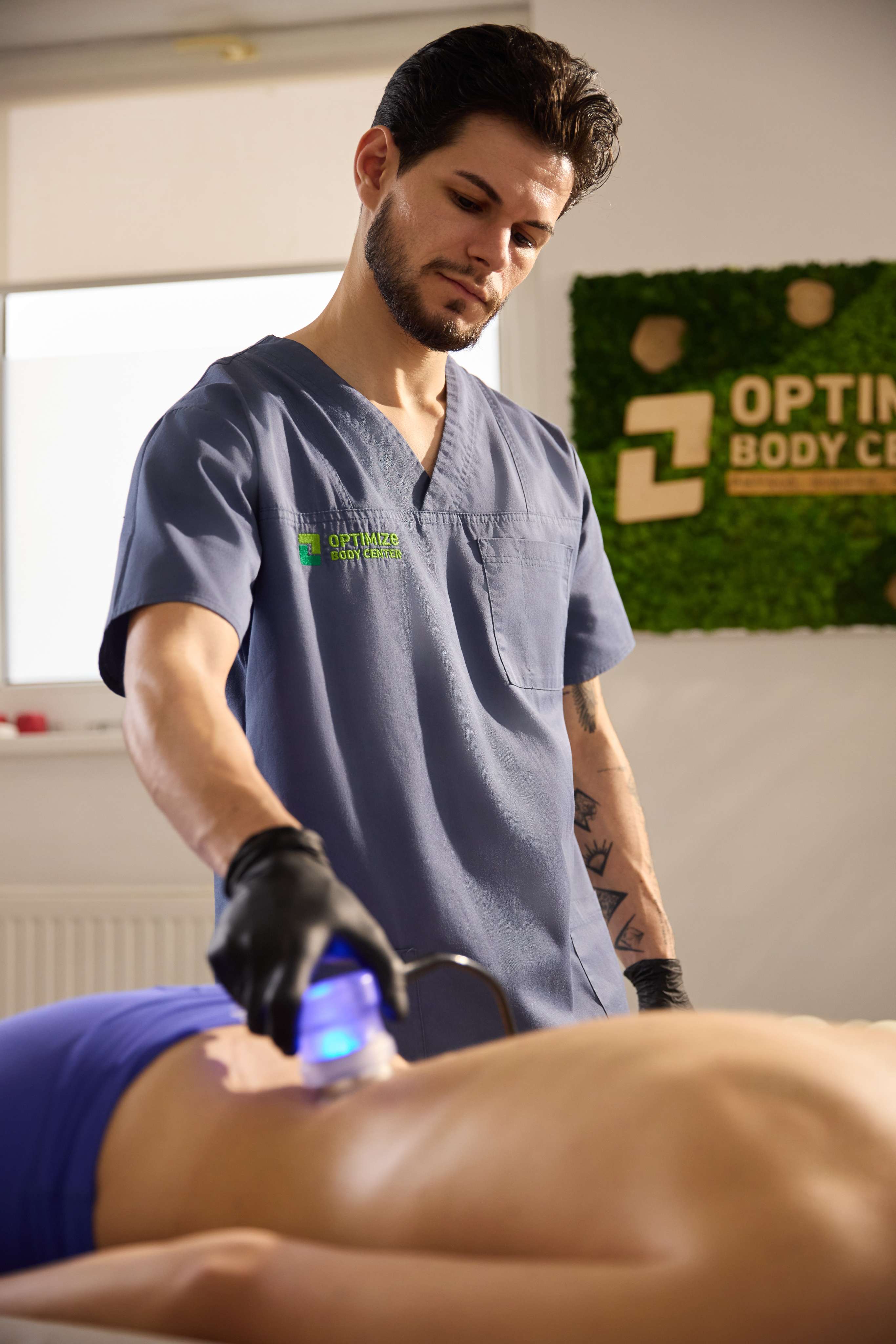 Physiotherapist using laser therapy on a patient in a clinic setting.